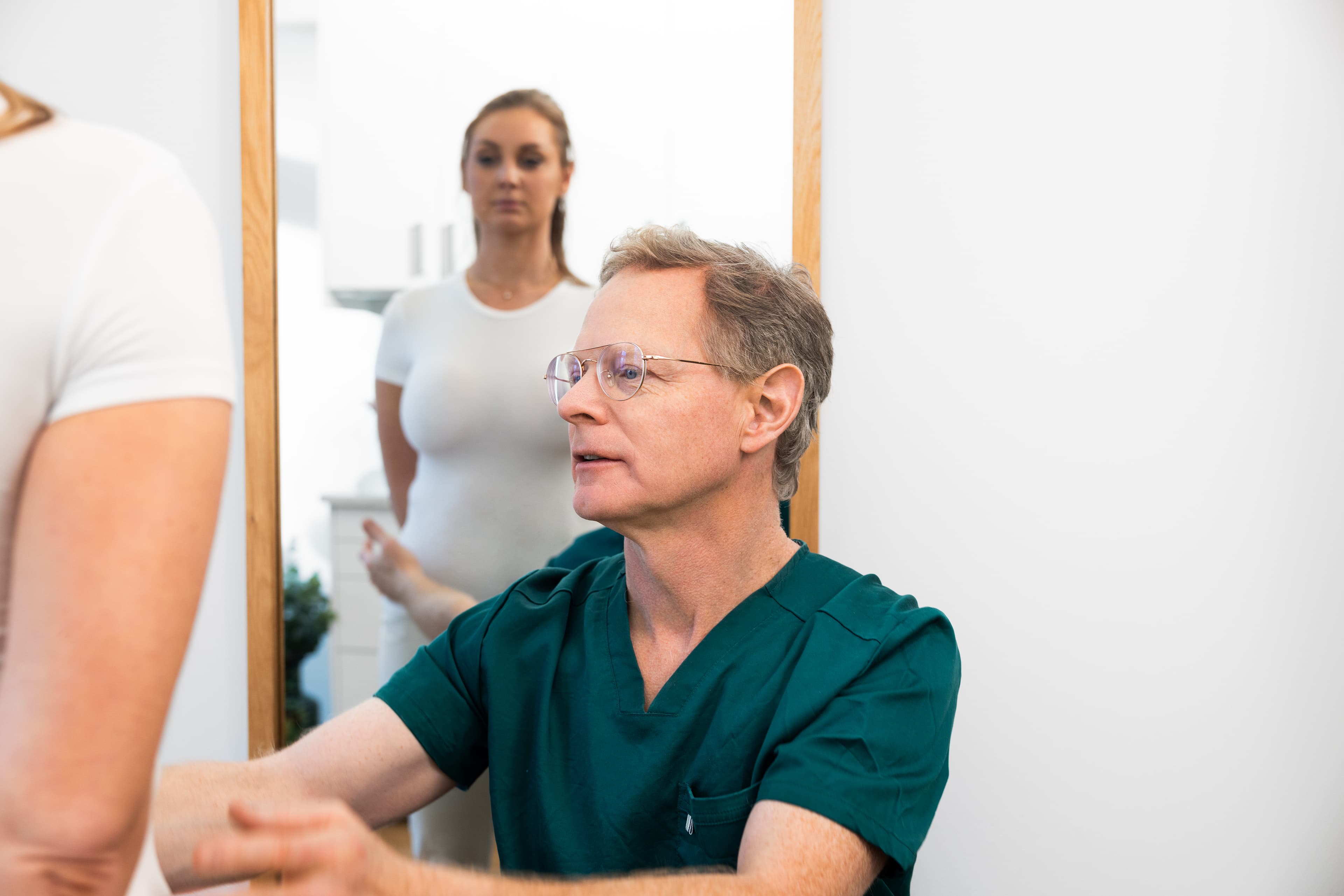 Dahliaklinikens Dr. Örja Gribbe konsulterar en förväntansfull ung kvinna om bröstförminskning