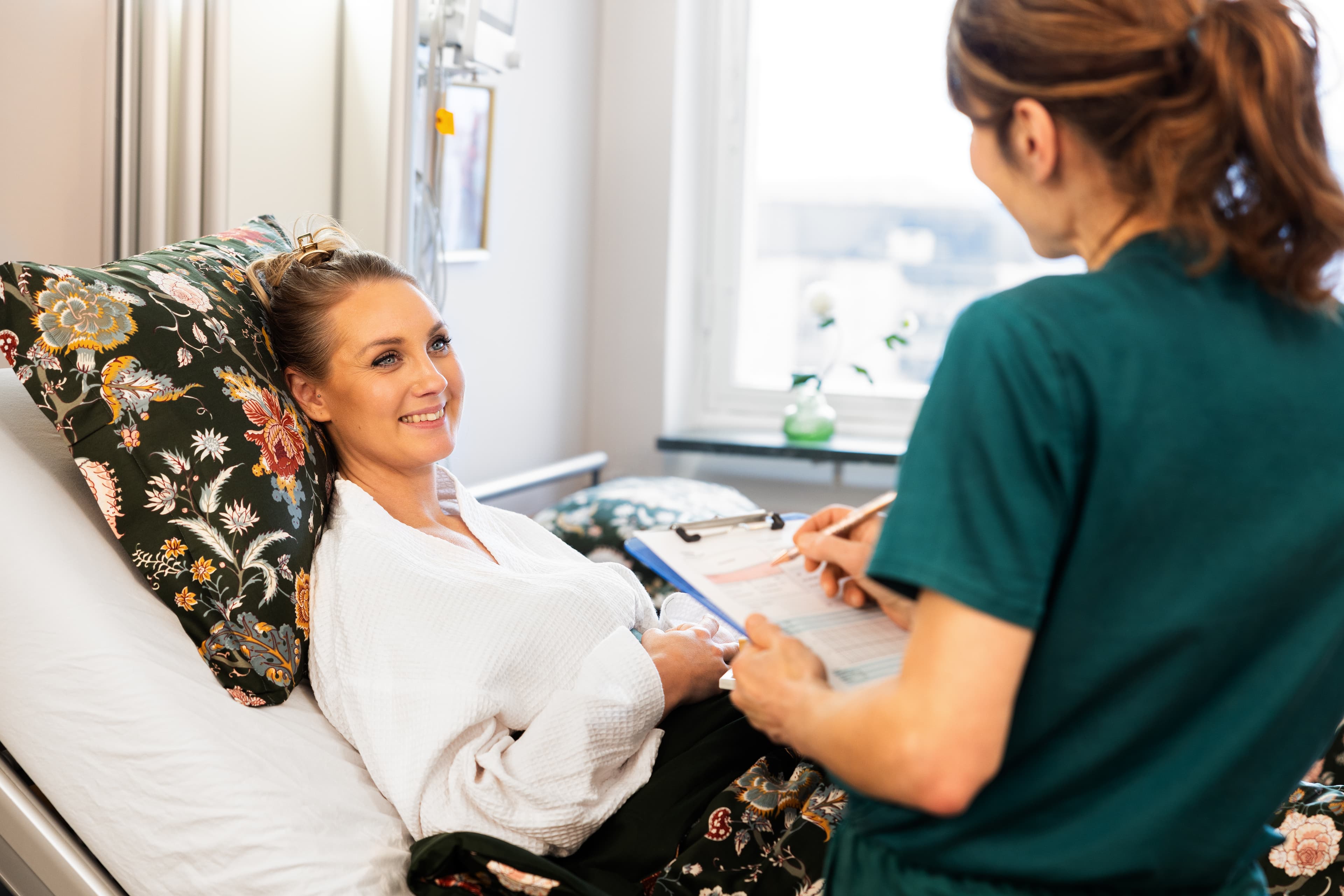 Dahliaklinikens Dr. Örja Gribbe konsulterar en förväntansfull ung kvinna om bröstförminskning